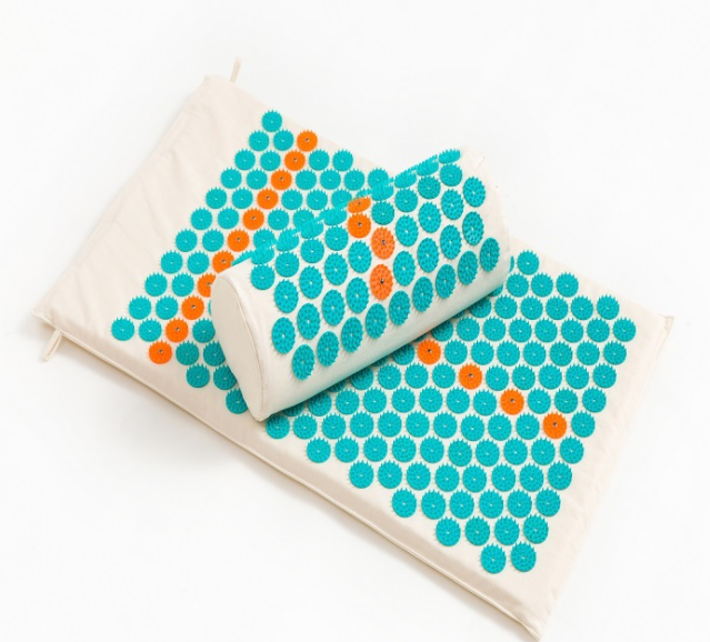 Lotus Spike Acupressure Mat for yoga, featuring a pillow and bag, promotes relaxation and ease in muscle tension.