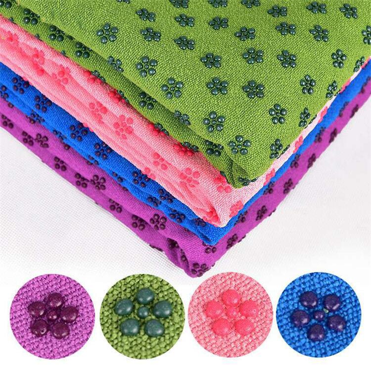 Colorful non slip yoga mat towel stacking display, featuring absorbent and slip-resistant fibers in multiple colors.